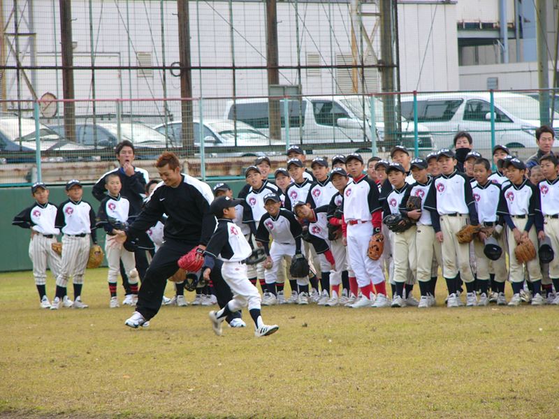 捕球練習をする参加者、栗山コーチは選手につきっきりで説明しました